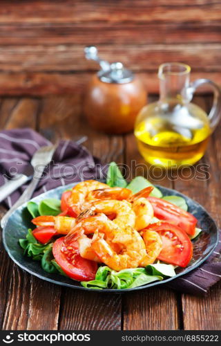 salad with shrimps on plate and on a table