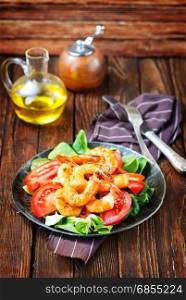 salad with shrimps on plate and on a table