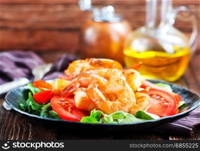 salad with shrimps on plate and on a table