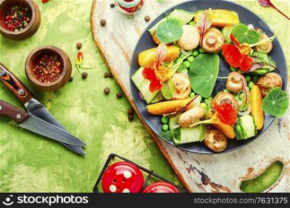 Salad with stewed mushrooms, cucumber,tomato and nasturtium.. Summer vegetable salad with flowers.
