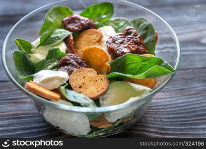 Salad with sun-dried tomatoes with mozzarella and spinach leaves