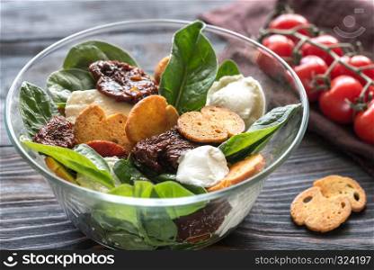 Salad with sun-dried tomatoes with mozzarella and spinach leaves