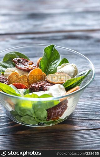Salad with sun-dried tomatoes with mozzarella and spinach leaves