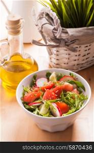 Salad with tomato, cucumber, radish, arugula and sesame seeds with olive oil
