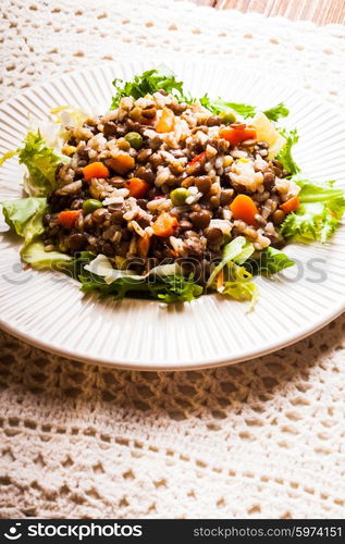 Salad with vegetables, rice and lentils on a plate