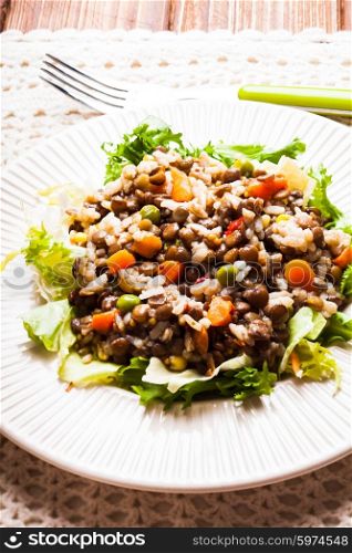 Salad with vegetables, rice and lentils on a plate
