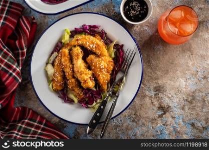 Salad with warm glazing chicken, sprinkled with sesame seeds. Chinese cuisine. Asian culture.