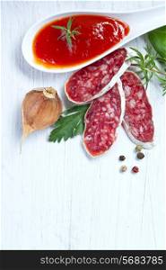 Salami on wooden board with rosemary