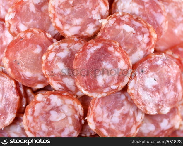 Salami sausage slices background. Close up. Slices of smoked sausage. Food background. Top view. Salami sausage slices background. Close up. Slices of smoked sausage. Food background.