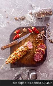 Salami sausage with slices on wooden board. Salami sausage with slices on wooden board on a table