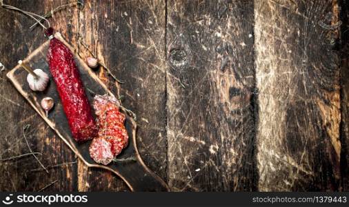 salami with herbs and spices on a board. On a wooden background.. salami with herbs and spices on a board.