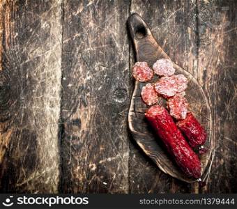 salami with herbs and spices on a board. On a wooden background.. salami with herbs and spices on a board.