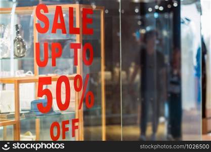 sale 50% off mock up advertise display frame setting over the glass in the clothes line shopping department store for shopping , business fashion and advertisement concept