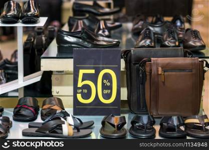 sale 50% off mock up advertise display frame setting over the men shoes shelf in the shopping department store for shopping, business fashion and advertisement concept