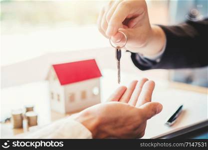 Sale agent giving Key house to customer and sign agreement contract, Insurance Home concept