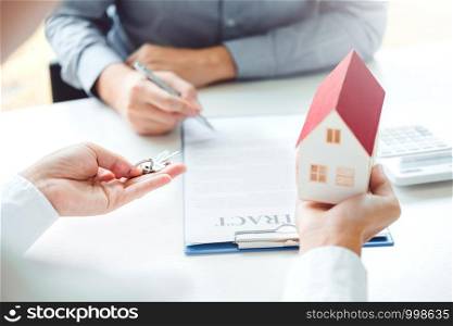 Sale agent giving Key house to customer and sign agreement contract, Insurance Home concept