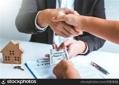 Sale Agent handshake with woman customer and sign agreement documents for realty purchase after successful loan contract .
