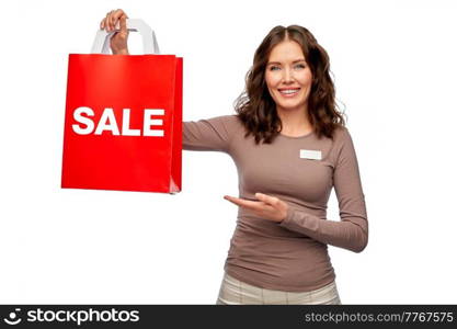 sale and business concept - happy female shop assistant or saleswoman holding shopping bags in both hands over white background. happy female shop assistant holding shopping bags