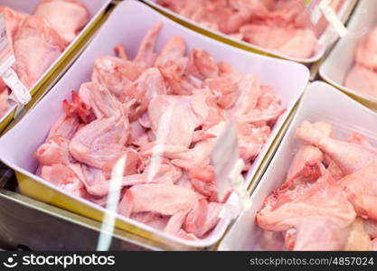 sale and food concept - poultry meat in bowls at grocery stall. poultry meat in bowls at grocery stall