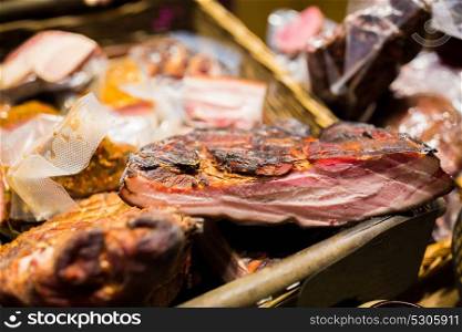 sale and food concept - smoked meat products at market or butcher shop. smoked meat products at market or butcher shop