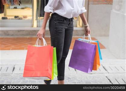 sale and people concept smiling young woman with shopping bags having fun with their purchases In the shopping mall