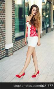 Sale and retail concept. Fashion woman girl in full length wearing elegant white dress, red red stilettos shoes. Young blonde fashion model shopping.