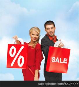 sale and shopping concept - smiling man and woman with shopping bag
