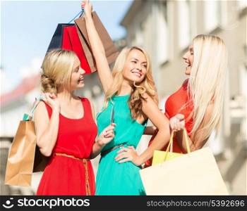 sale and tourism, happy people concept - beautiful blonde women with shopping bags in the ctiy