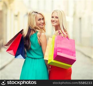 sale and tourism, happy people concept - beautiful women with shopping bags in the ctiy