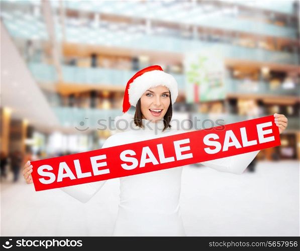 sale, christmas, holidays and people concept - smiling woman in santa helper hat with red sale sign over shopping center background