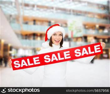 sale, christmas, holidays and people concept - smiling woman in santa helper hat with red sale sign over shopping center background