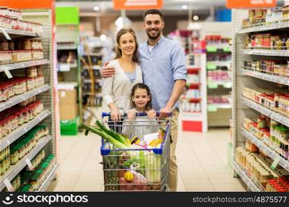 sale, consumerism and people concept - happy family with child and shopping cart buying food at grocery store or supermarket