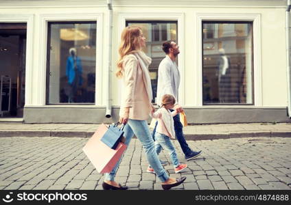 sale, consumerism and people concept - happy family with little child and shopping bags in city