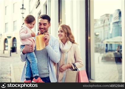 sale, consumerism and people concept - happy family with little child and shopping bags in city. happy family with child and shopping bags in city