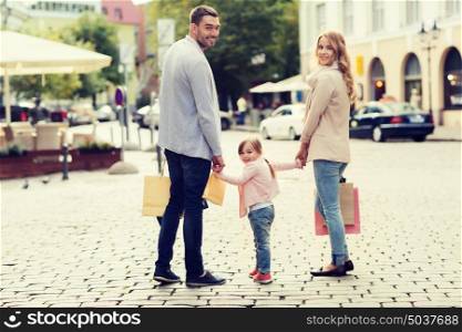 sale, consumerism and people concept - happy family with little child and shopping bags in city. happy family with child and shopping bags in city