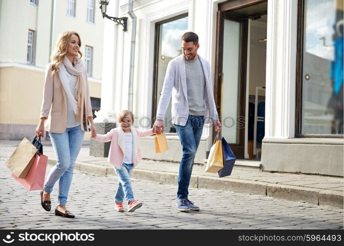 sale, consumerism and people concept - happy family with little child and shopping bags in city