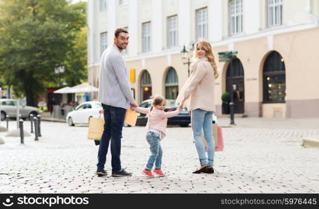 sale, consumerism and people concept - happy family with little child and shopping bags in city