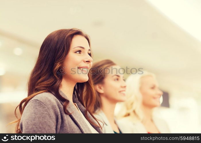 sale, consumerism and people concept - happy young women in mall or business center