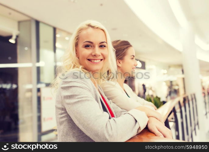 sale, consumerism and people concept - happy young women in mall or business center