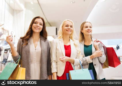 sale, consumerism and people concept - happy young women with shopping bags in mall