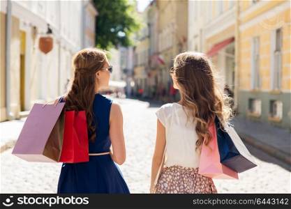 sale, consumerism and people concept - happy young women with shopping bags on city street. happy women with shopping bags on city street