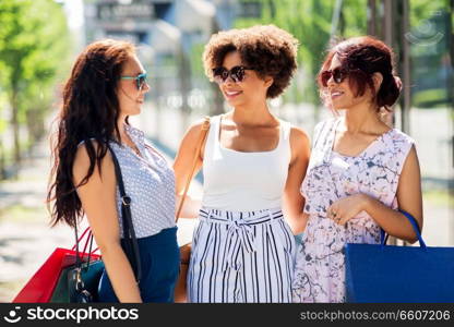 sale, consumerism and people concept - happy young women with shopping bags on city street. happy women with shopping bags in city