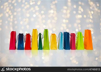 sale, consumerism and retail concept - many colorful shopping bags over holidays lights background