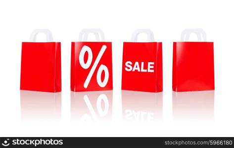 sale, consumerism, discount, advertisement and retail concept - many red shopping bags with percentage sign