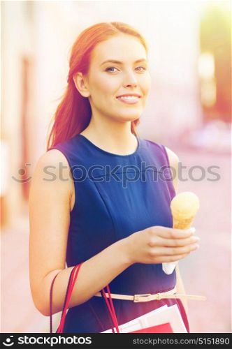 sale, consumerism, summer and people concept - happy young woman with shopping bags and ice cream on city street. woman with shopping bags and ice cream in city