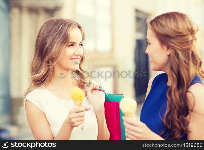 sale, consumerism, summer and people concept - happy young women with shopping bags and ice cream talking on city street