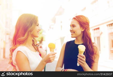 sale, consumerism, summer and people concept - happy young women with shopping bags and ice cream talking on city street. woman with shopping bags and ice cream in city