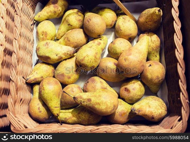 sale, farming, harvest, agriculture and eco food concept - ripe apples in basket at bio market or farm