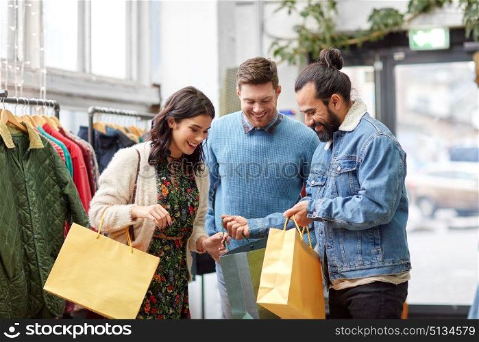 sale, fashion and people concept - happy friends with shopping bags at vintage clothing store. friends shopping bags at vintage clothing store. friends shopping bags at vintage clothing store