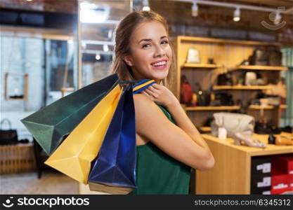 sale, fashion and people concept - happy young woman with shopping bags at at at shoestore. happy young woman with shopping bags at shoestore